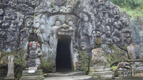 Carved stone gateway of a Balinese temple near Ubud, framed by tropical greenery